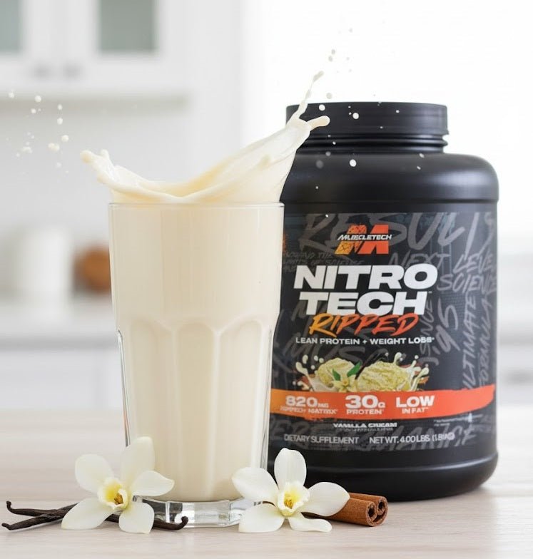 A glass of vanilla-flavored Muscle Tech Nitro-Tech Ripped protein shake with a dynamic splash, displayed next to the product tub, vanilla flowers, and cinnamon sticks.